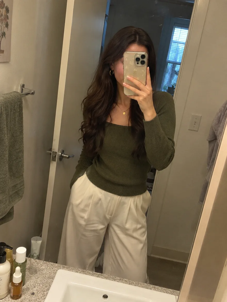 Selfie en el espejo con suéter verde olivo y pantalón crema